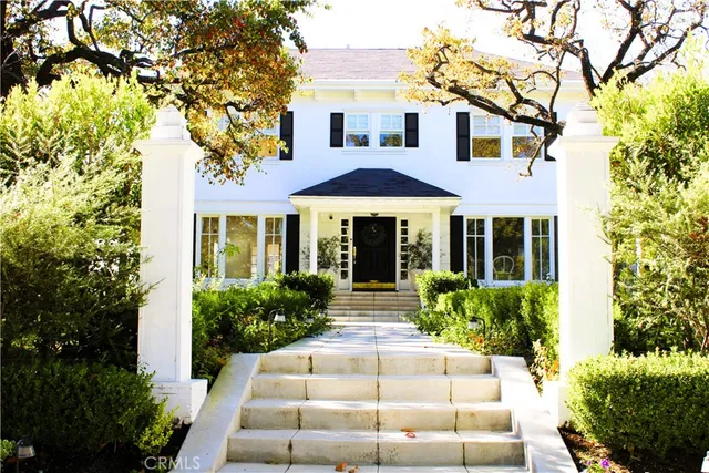 an aerial view of residential houses with outdoor space and trees