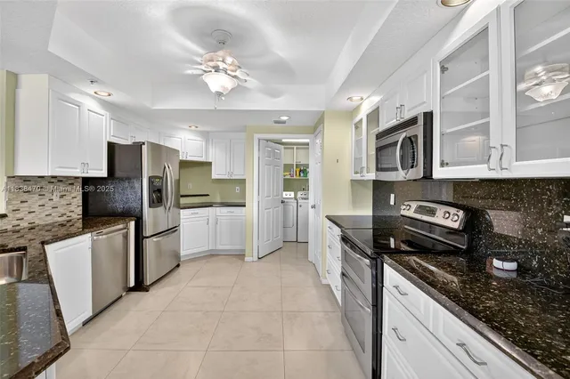 a kitchen with granite countertop a sink and cabinets
