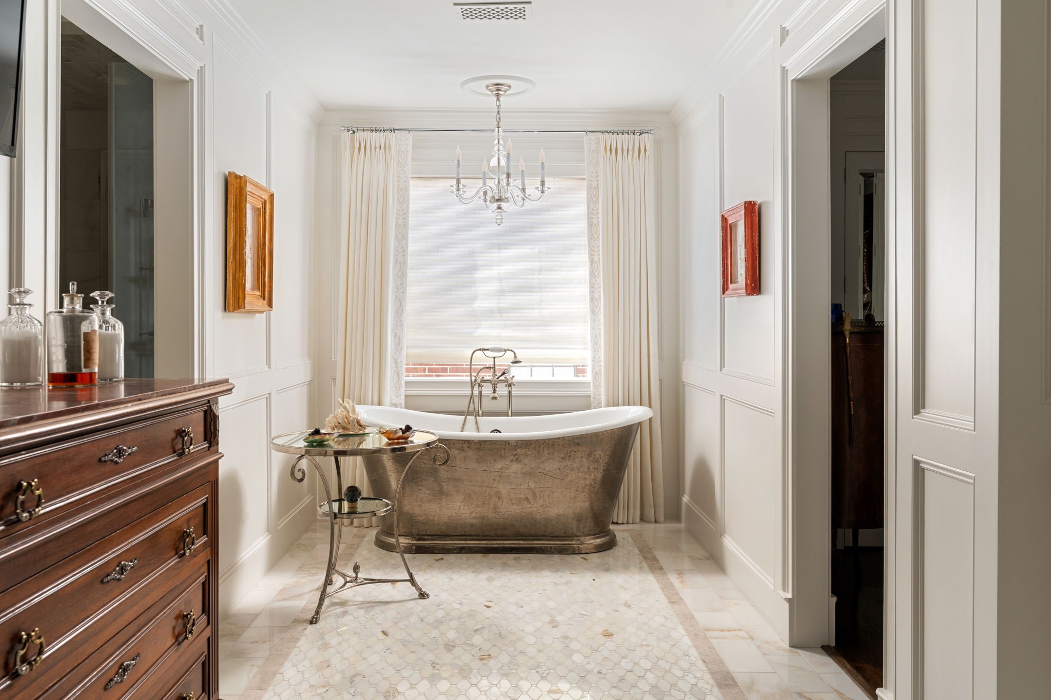 2017 Dryden Road Houston, TX 77030 - Photo 29 of 40 The primary bathroom unfolds like a private spa corridor. Dual vanities keep the peace. Marble floors run underfoot with quiet elegance. A soaking tub sits centered and confident, framed by tall windows that invite in filtered daylight without sacraficing privacy.