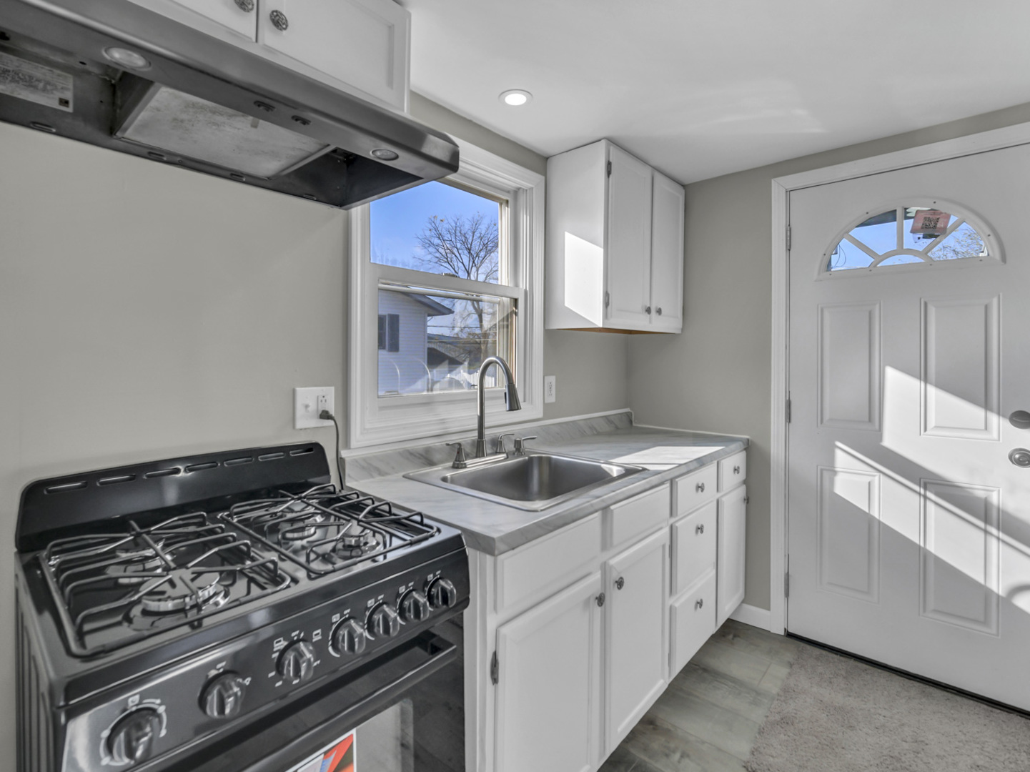 1820 Tomahawk Trail Round Lake Heights, IL 60073 - Photo 8 of 23 a kitchen with a stove and white cabinets