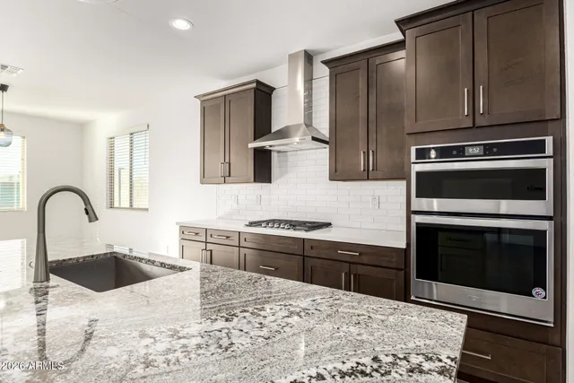 a kitchen with granite countertop a stove a sink and refrigerator