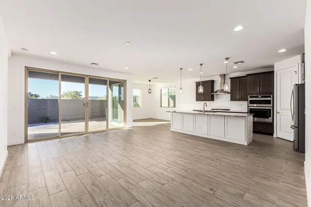 a large kitchen with stainless steel appliances kitchen island a large counter top and a wooden floors