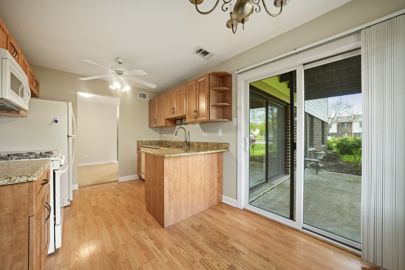924 Coach Road, Unit 1 Palatine, IL 60074 - Photo 7 of 23 a kitchen with stainless steel appliances granite countertop a stove a refrigerator a sink and white cabinets with wooden floor