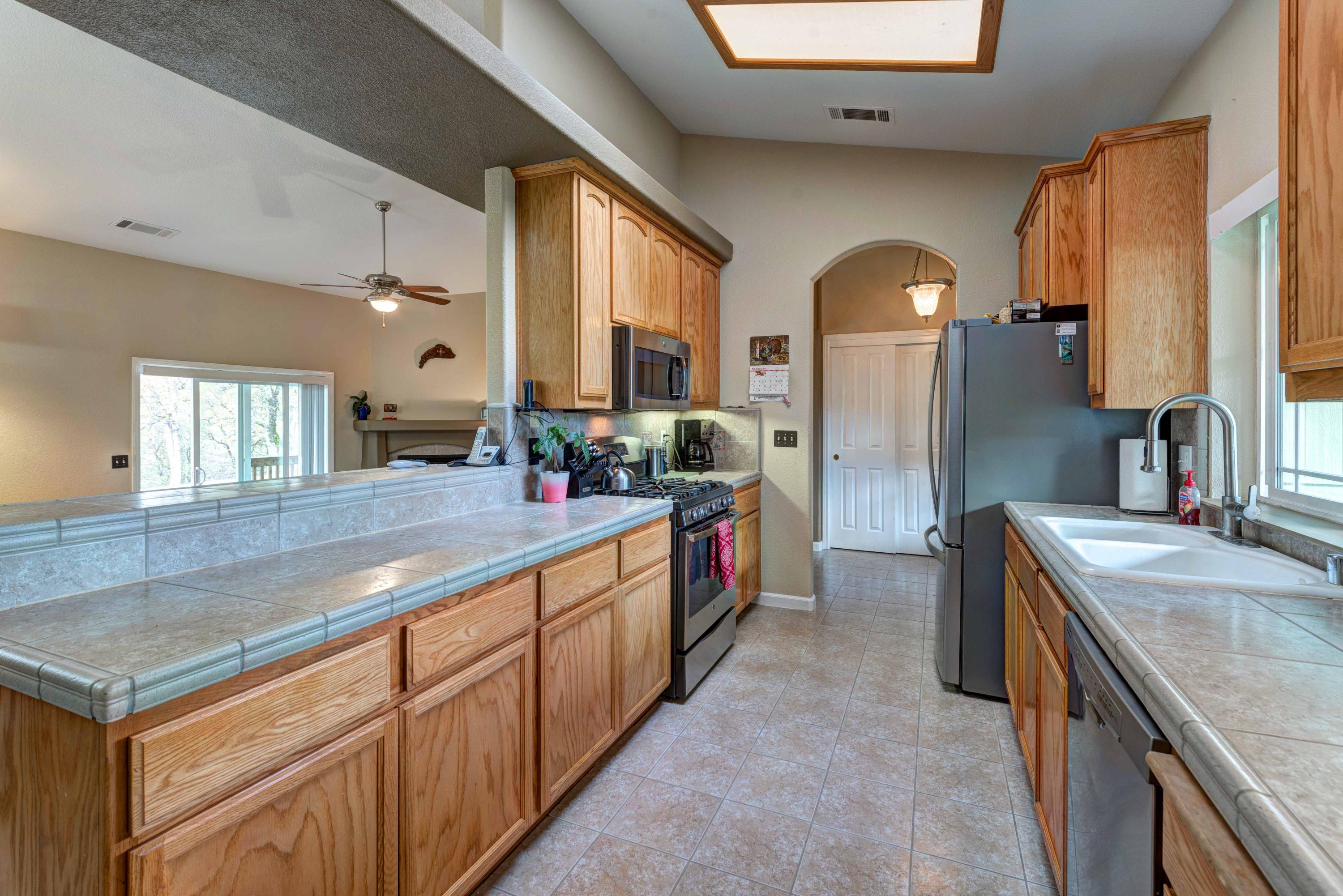 13711 Gas Point Road Igo, CA 96047 - Photo 12 of 29 a large kitchen with stainless steel appliances granite countertop a sink and a refrigerator