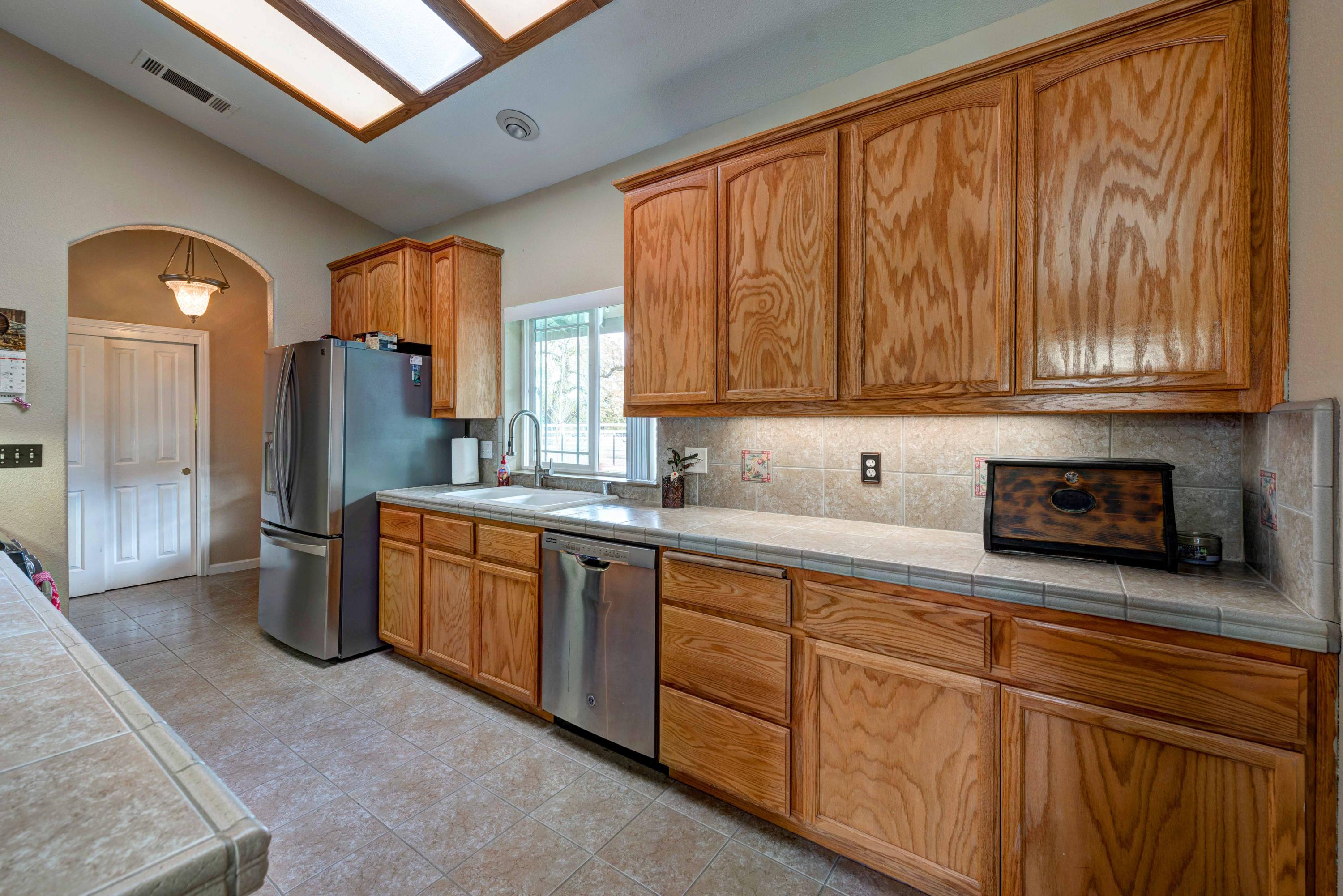 13711 Gas Point Road Igo, CA 96047 - Photo 13 of 29 a kitchen with stainless steel appliances granite countertop a sink dishwasher stove and refrigerator with wooden floor