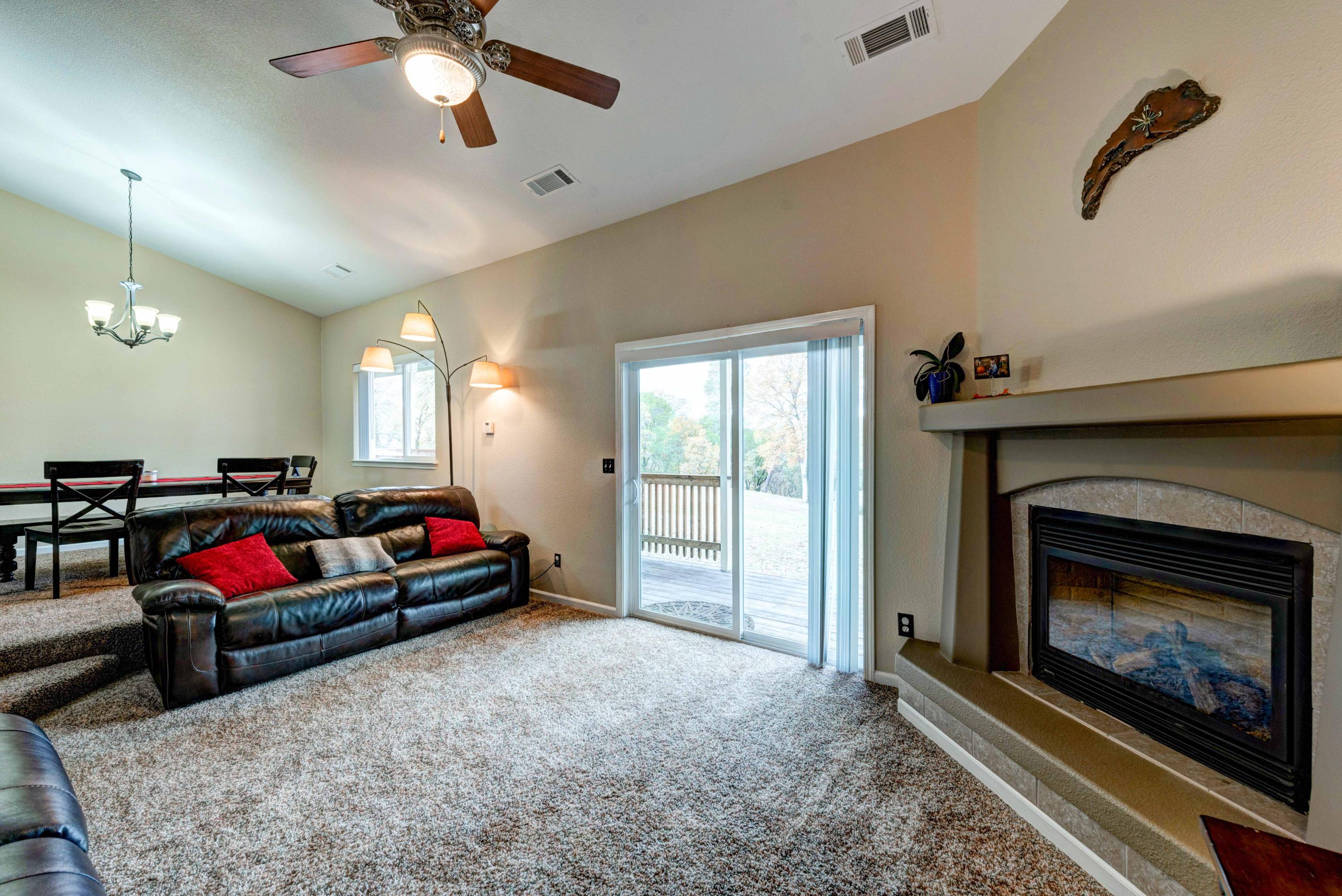 13711 Gas Point Road Igo, CA 96047 - Photo 9 of 29 a living room with furniture a fireplace and a chandelier