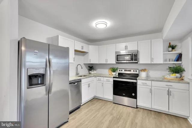 a kitchen with cabinets stainless steel appliances and a counter space