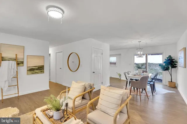 a living room with furniture a dining table and a large window