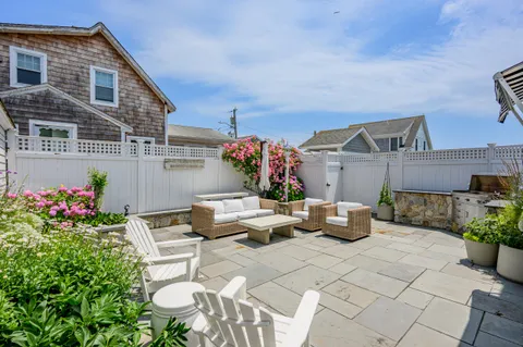 a view of a patio with couches table and chairs and potted plants