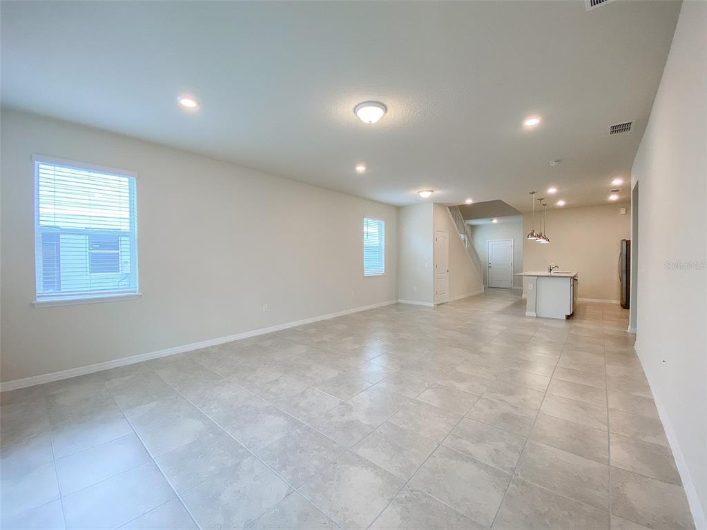 7208 Oakmoss Loop Davenport, FL 33837 - Photo 11 of 46 a view of a big room with a kitchen and windows