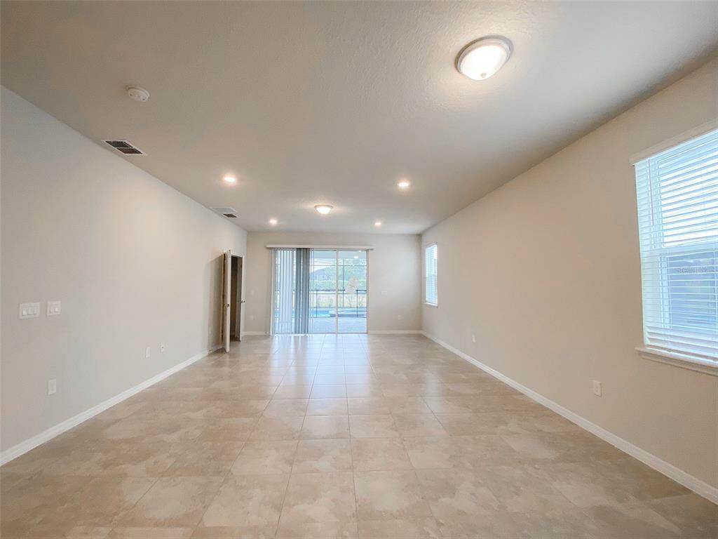 7208 Oakmoss Loop Davenport, FL 33837 - Photo 15 of 46 an empty room with windows and pillars in it