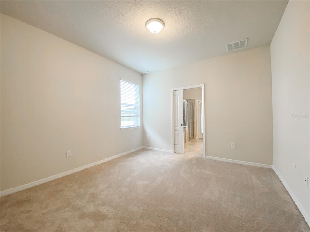7208 Oakmoss Loop Davenport, FL 33837 - Photo 18 of 46 an empty room with windows and closet
