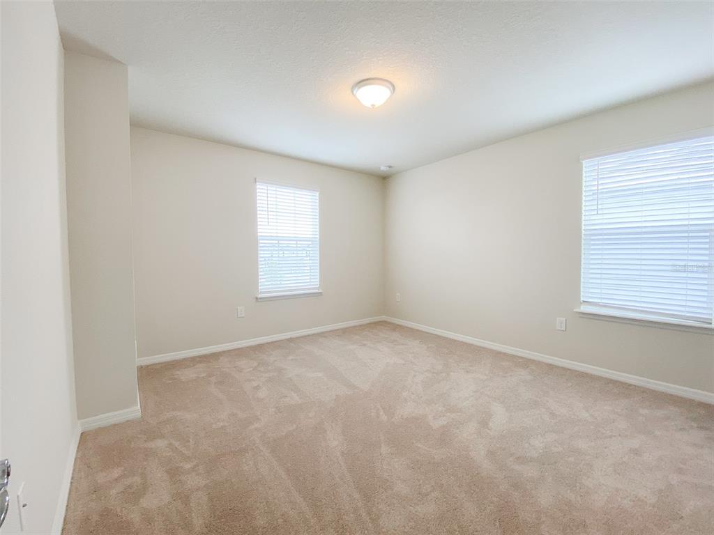7208 Oakmoss Loop Davenport, FL 33837 - Photo 24 of 46 an empty room with windows