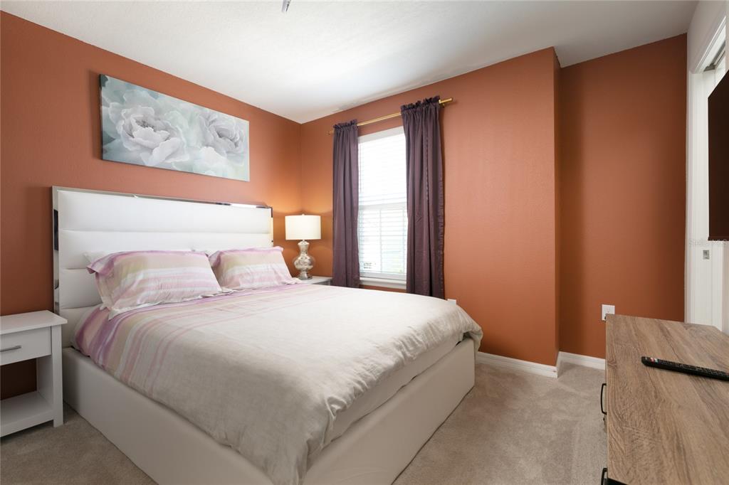 7208 Oakmoss Loop Davenport, FL 33837 - Photo 33 of 46 a bedroom with a large bed and a window