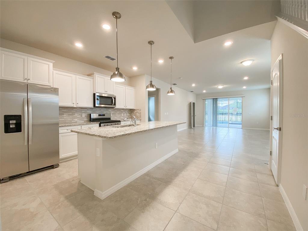 7208 Oakmoss Loop Davenport, FL 33837 - Photo 6 of 46 a view of kitchen with refrigerator sink and stove
