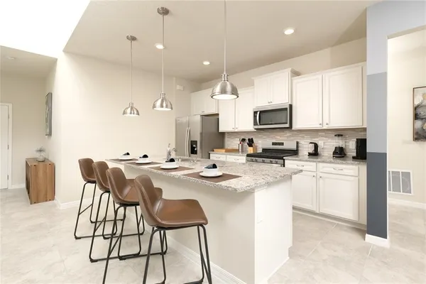 a large kitchen with kitchen island a sink a stove a refrigerator and a cabinets