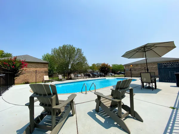 an outdoor sitting area with furniture and umbrella
