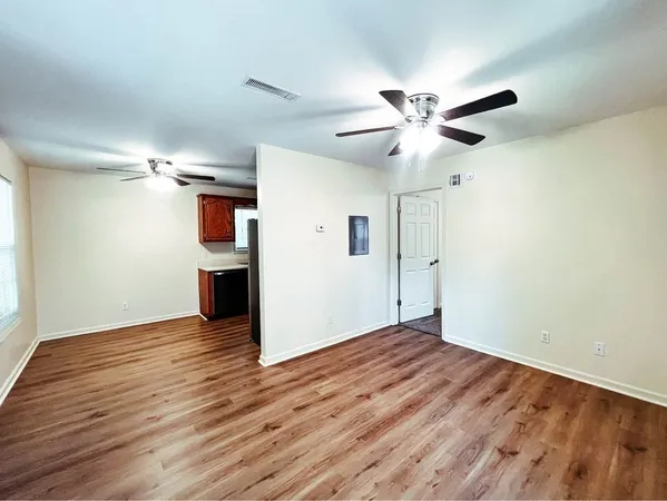 a view of empty room with wooden floor