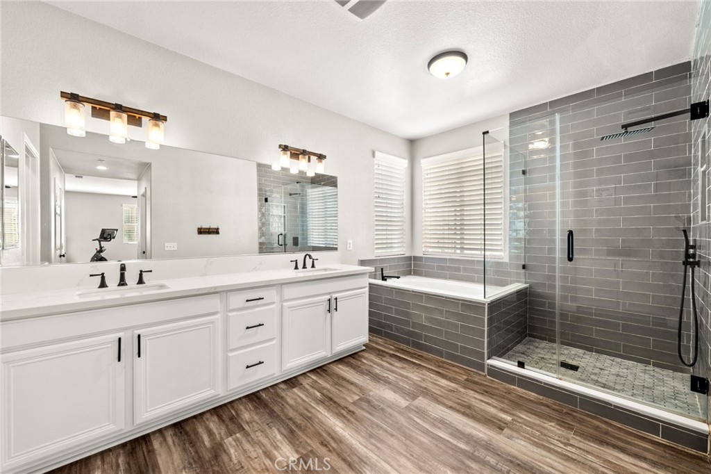 19791 Paso Robles Drive Riverside, CA 92508 - Photo 24 of 29 a bathroom with a double vanity sink a large mirror and a bathtub