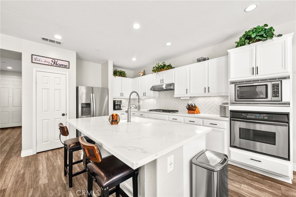 19791 Paso Robles Drive Riverside, CA 92508 - Photo 6 of 29 a kitchen with stainless steel appliances a stove a table and chairs