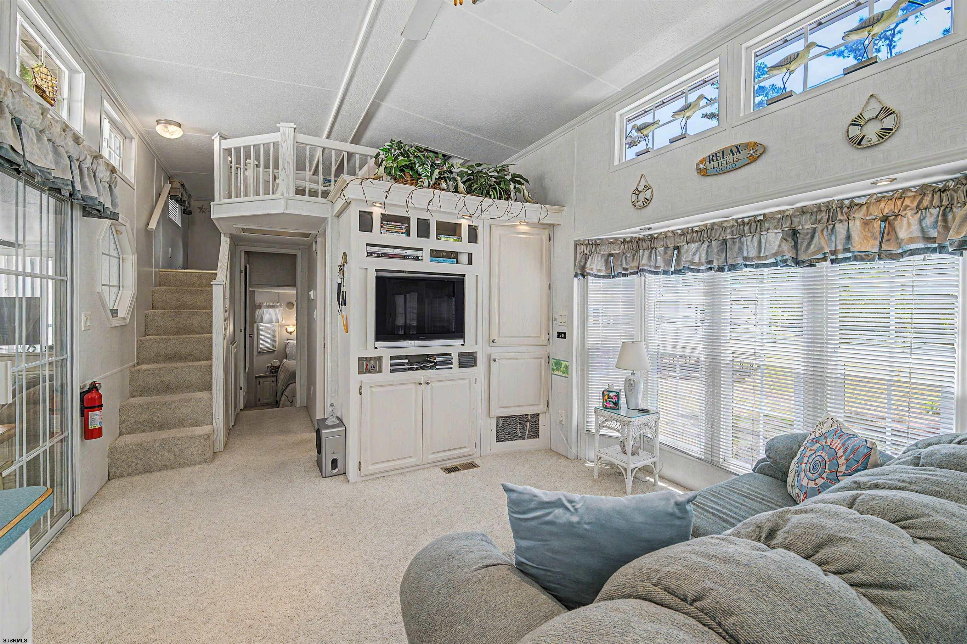 3066 Route 9 Ocean View, NJ 08230 - Photo 19 of 29 a living room with furniture a flat screen tv and a floor to ceiling window