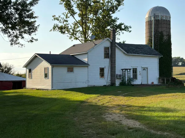a view of a yard in front of a house with large trees