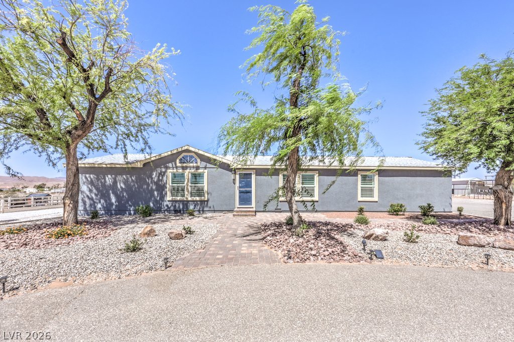 4375 Pinwheel Street Logandale, NV 89021 - Photo 4 of 52 Mature trees frame the welcoming entrance of this charming residence.