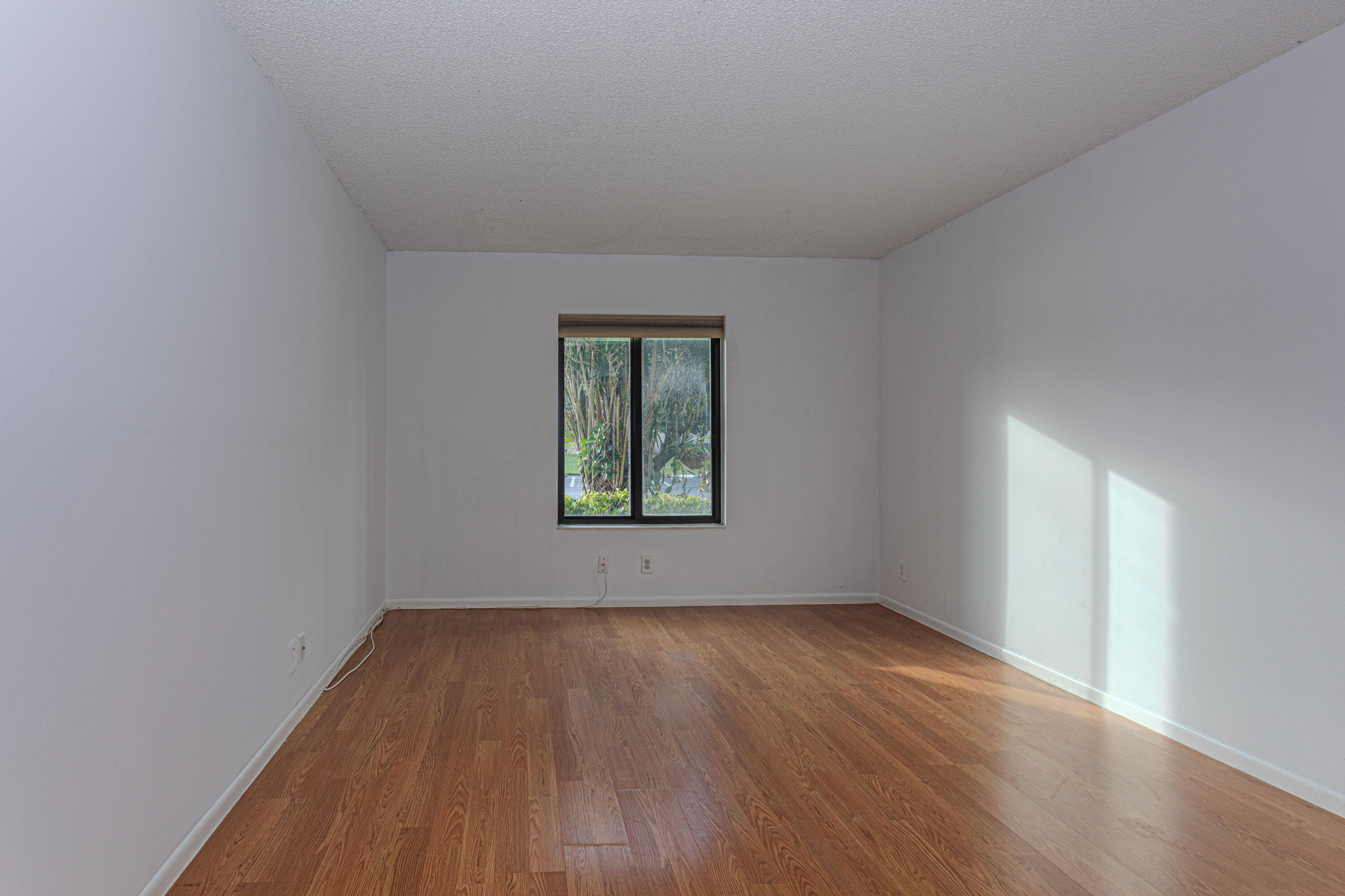 603 Sea Pine Way, Unit C1 Greenacres, FL 33415 - Photo 12 of 32 an empty room with wooden floor and windows