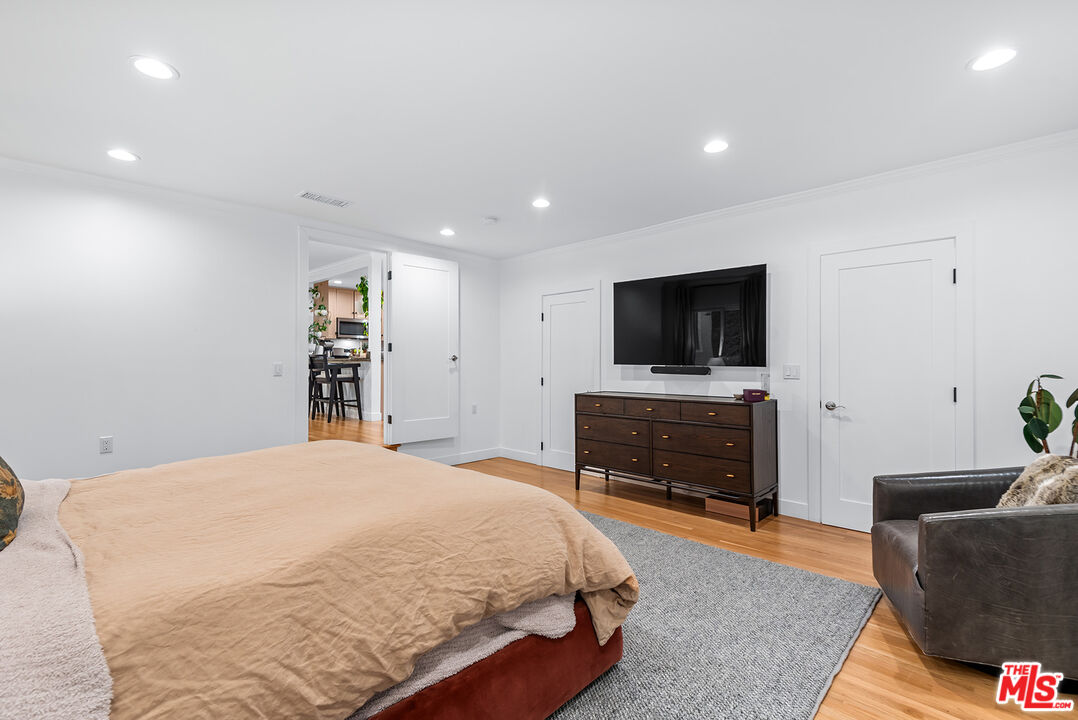 2621 Mandeville Canyon Road Los Angeles, CA 90049 - Photo 12 of 30 a spacious bedroom with a bed and a flat screen tv