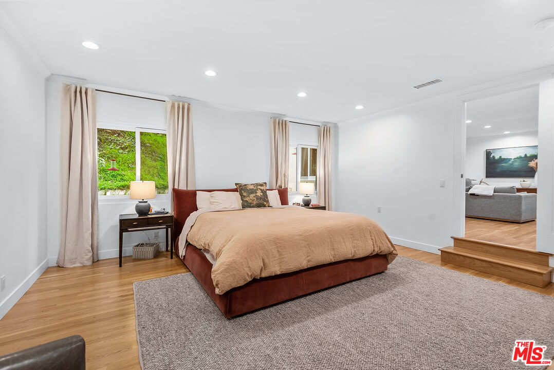 2621 Mandeville Canyon Road Los Angeles, CA 90049 - Photo 13 of 30 a bedroom with a bed and a large window