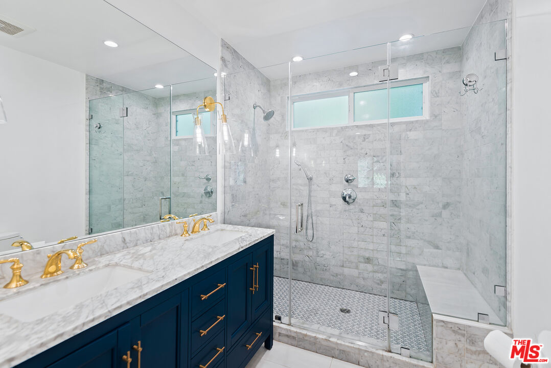 2621 Mandeville Canyon Road Los Angeles, CA 90049 - Photo 14 of 30 a bathroom with a granite countertop sink mirror and shower
