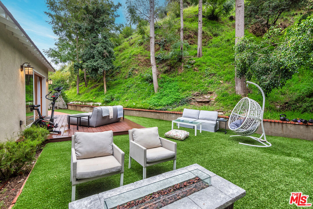 2621 Mandeville Canyon Road Los Angeles, CA 90049 - Photo 22 of 30 a view of a chair and table back yard of the house