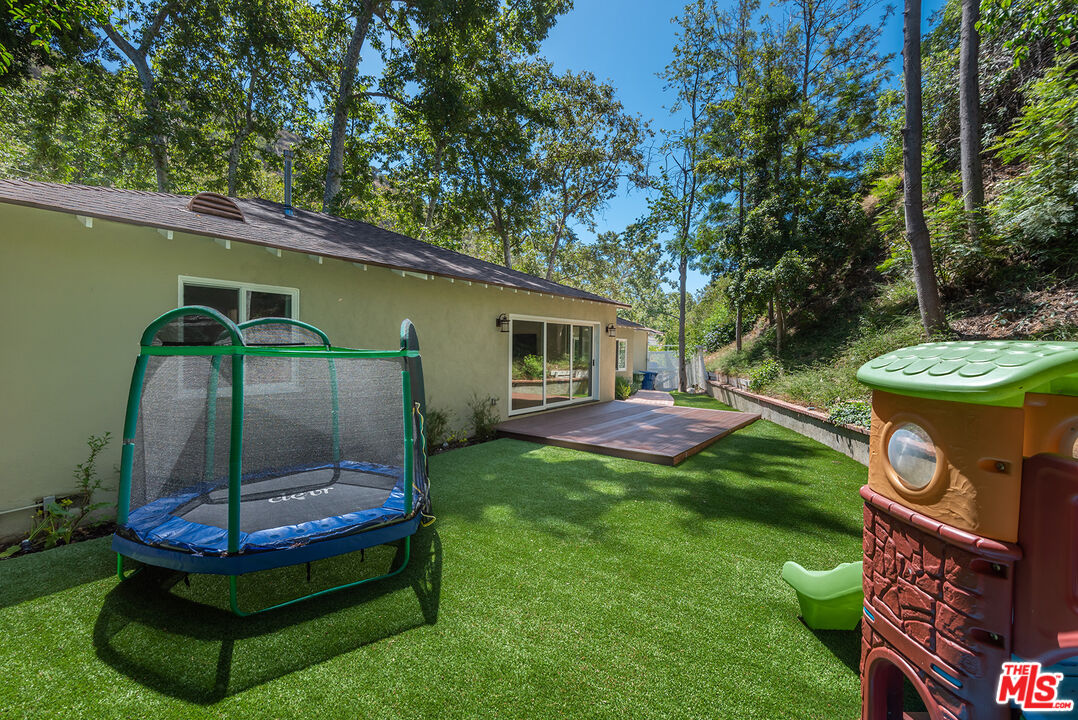 2621 Mandeville Canyon Road Los Angeles, CA 90049 - Photo 25 of 30 a backyard of a house with yard and outdoor seating