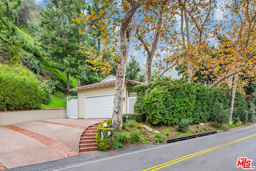 2621 Mandeville Canyon Road Los Angeles, CA 90049 - Photo 28 of 30 a view of a house with a tree and plant