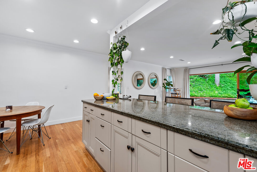 2621 Mandeville Canyon Road Los Angeles, CA 90049 - Photo 10 of 30 a kitchen with granite countertop a stove a sink and a potted plant