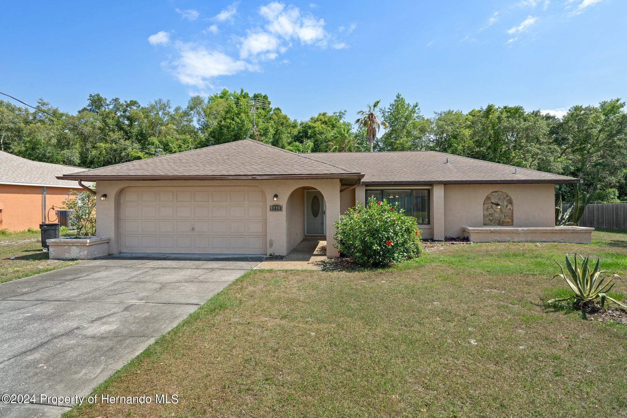 9290 Eldridge Road Spring Hill, FL 34608 - Photo 1 of 55 a front view of a house with a garden and yard