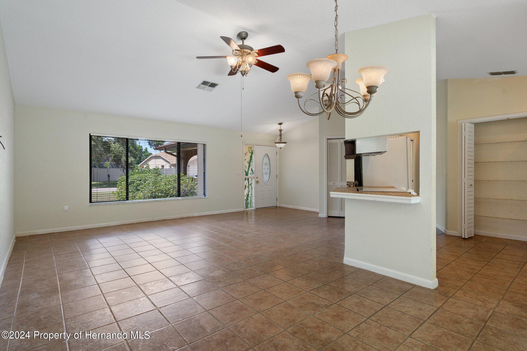 9290 Eldridge Road Spring Hill, FL 34608 - Photo 12 of 55 a view of a room with a chandelier fan and windows