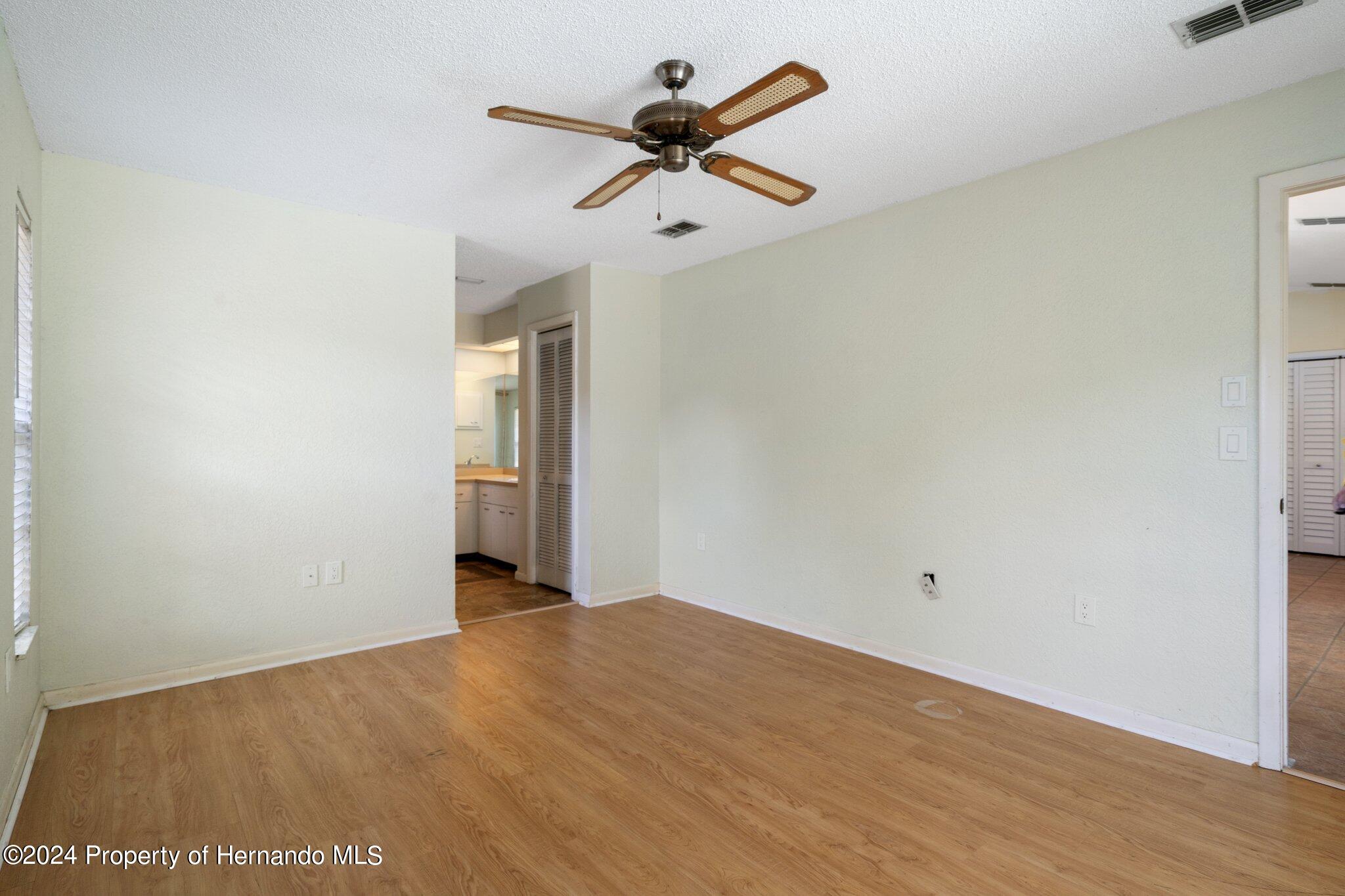 9290 Eldridge Road Spring Hill, FL 34608 - Photo 22 of 55 a view of empty room with wooden floor