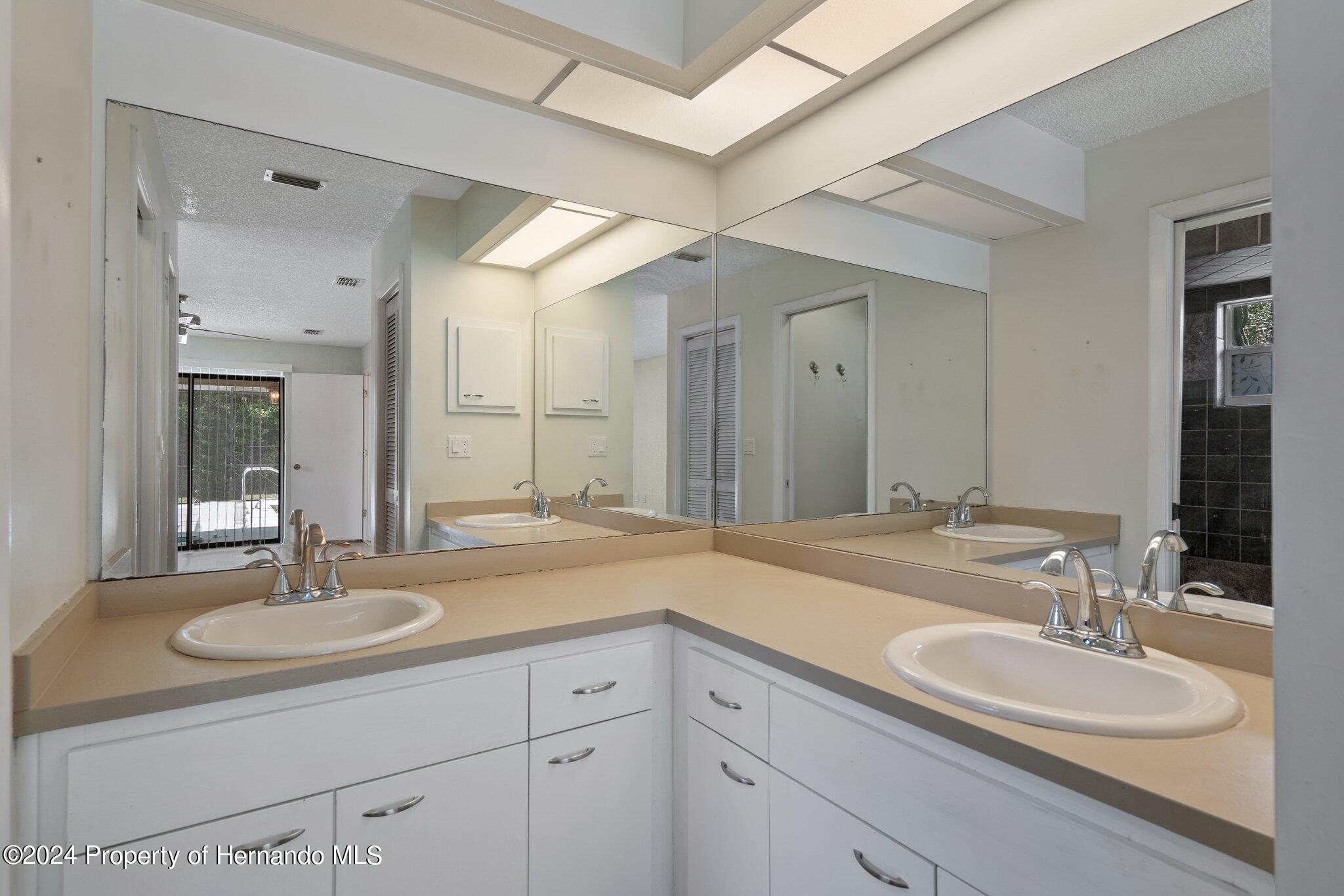 9290 Eldridge Road Spring Hill, FL 34608 - Photo 24 of 55 a bathroom with double sink and a mirror