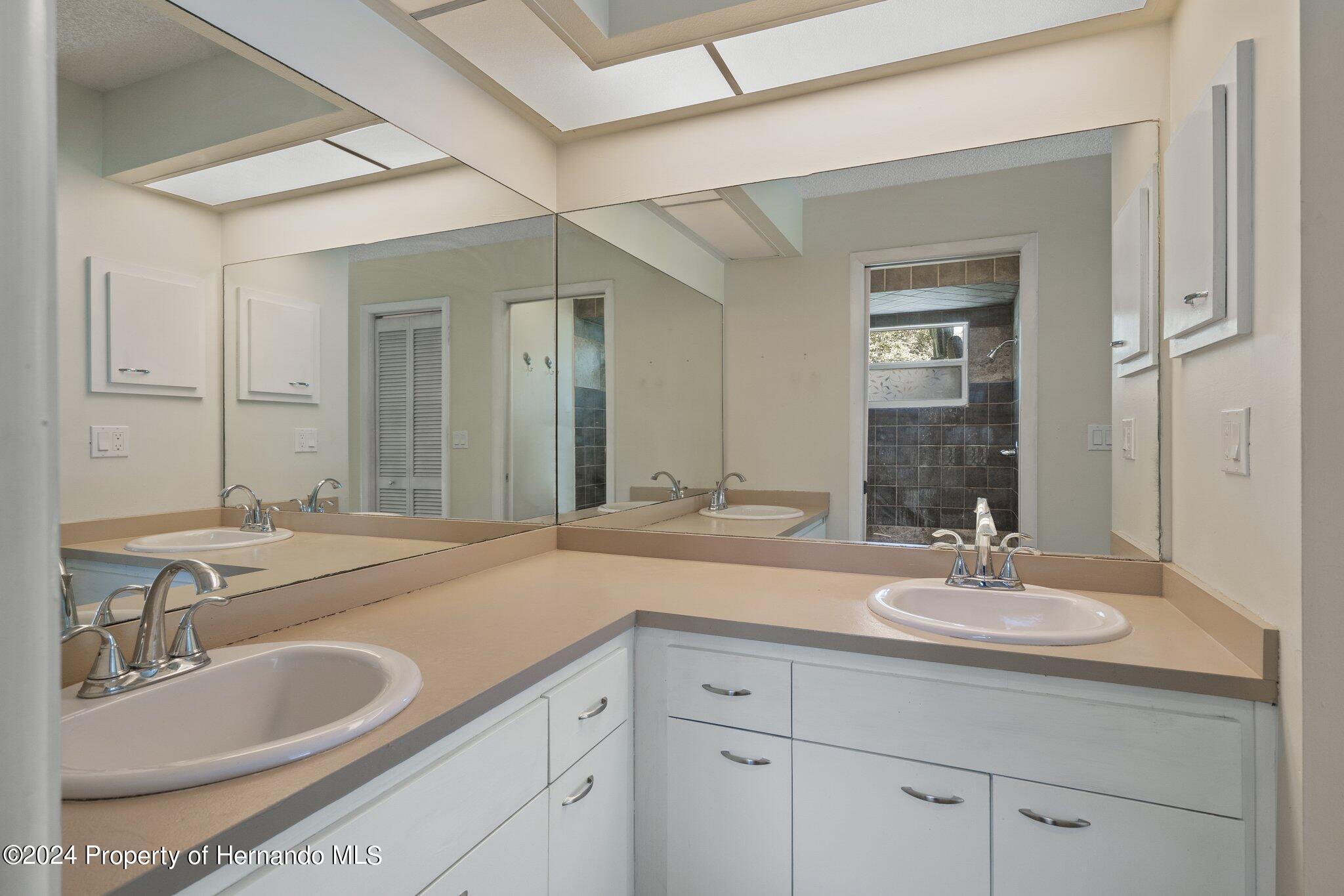 9290 Eldridge Road Spring Hill, FL 34608 - Photo 25 of 55 a bathroom with double sink and a mirror