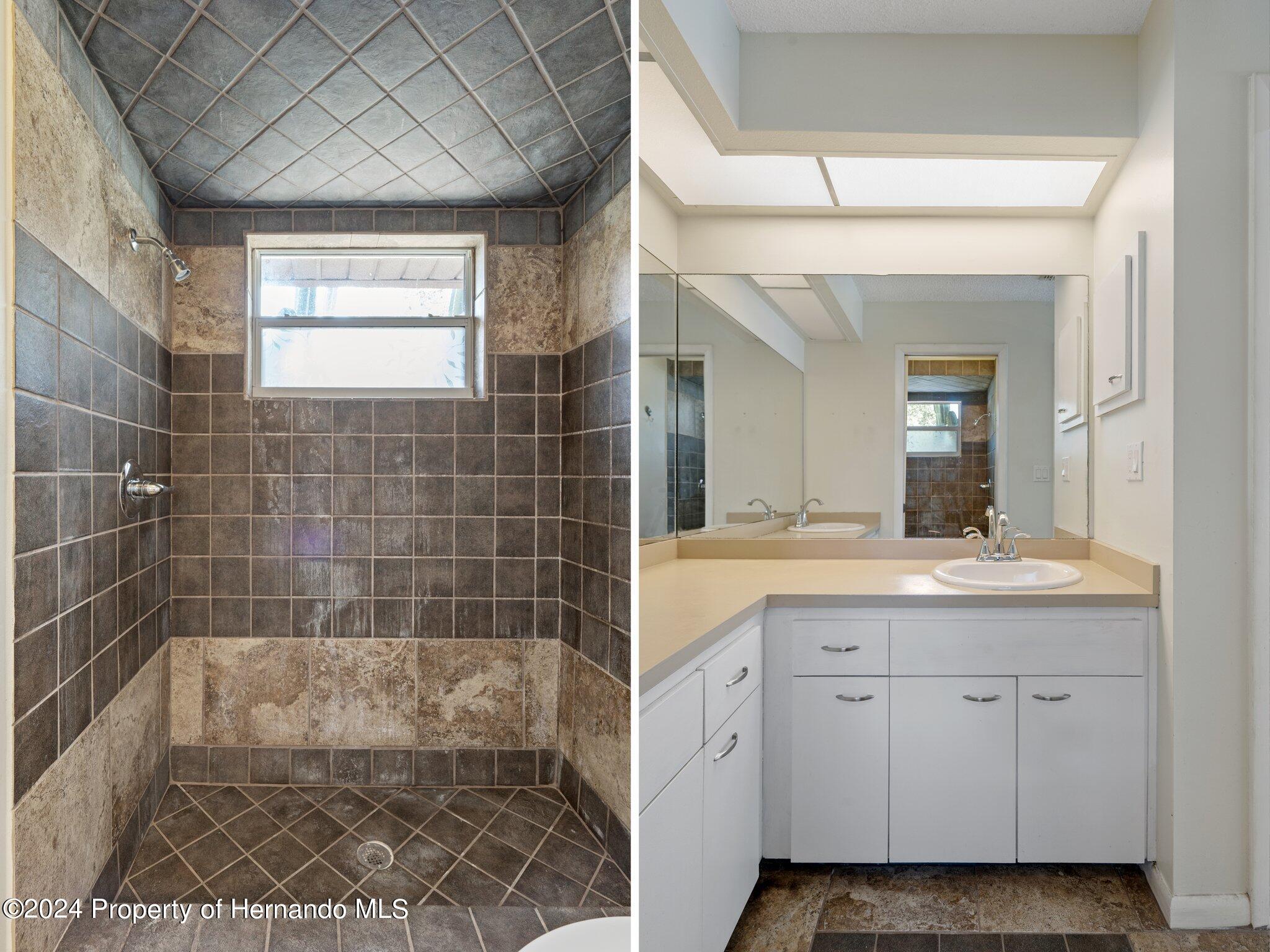 9290 Eldridge Road Spring Hill, FL 34608 - Photo 27 of 55 a bathroom with a granite countertop sink a toilet a mirror and shower