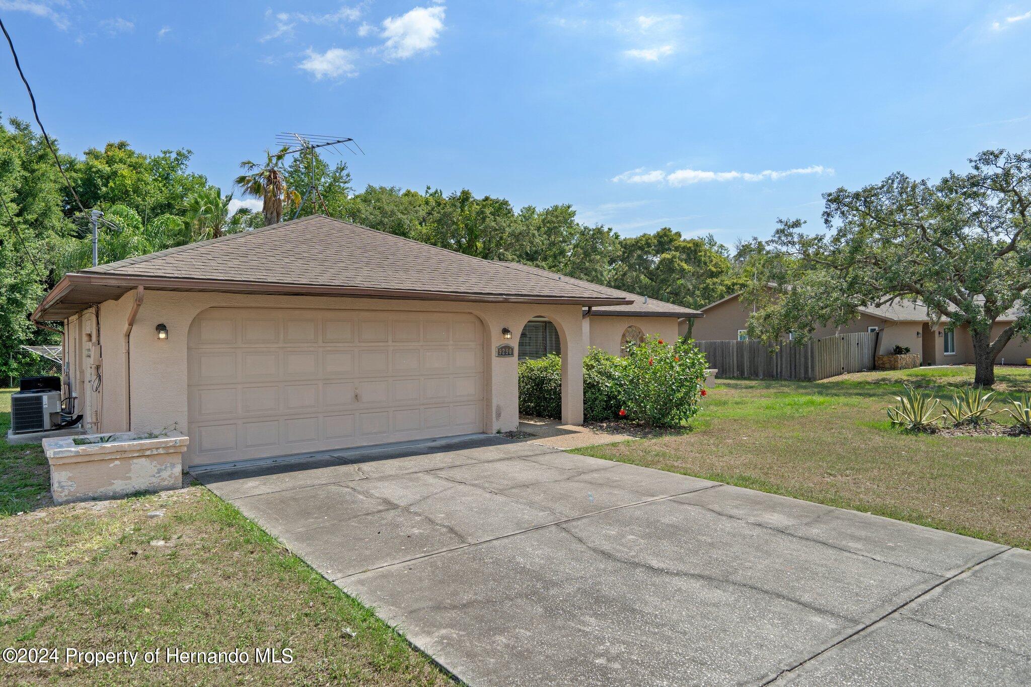 9290 Eldridge Road Spring Hill, FL 34608 - Photo 3 of 55 a front view of a house with a yard and garage