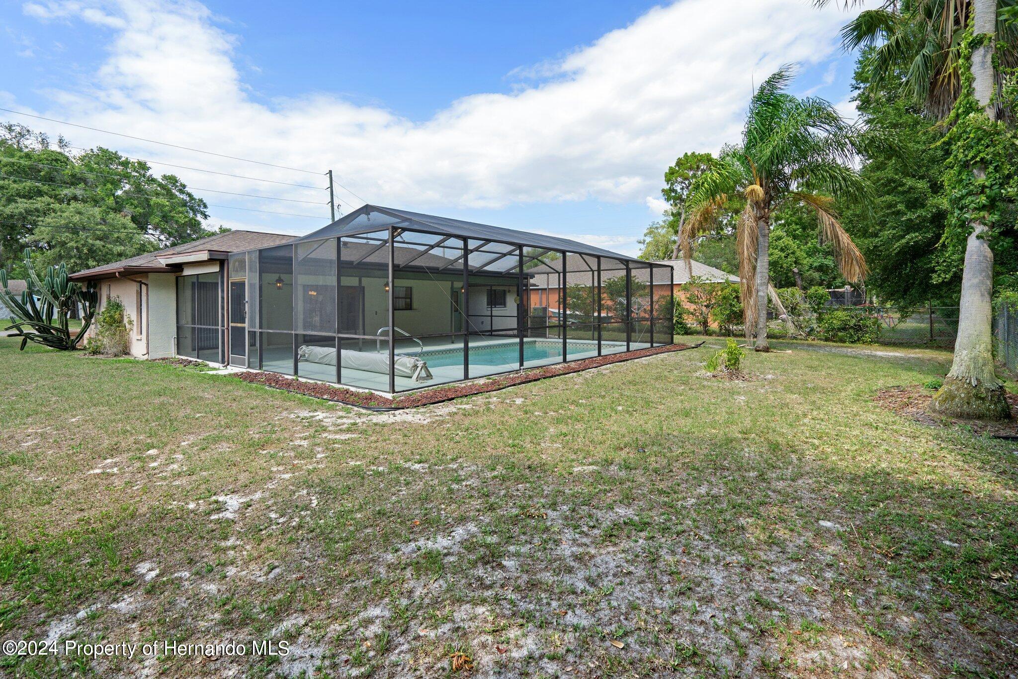 9290 Eldridge Road Spring Hill, FL 34608 - Photo 54 of 55 a view of a house with backyard and a garden