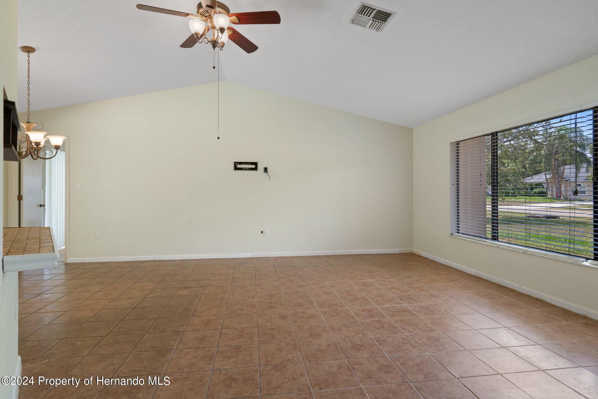 9290 Eldridge Road Spring Hill, FL 34608 - Photo 7 of 55 a view of a livingroom with a ceiling fan and window