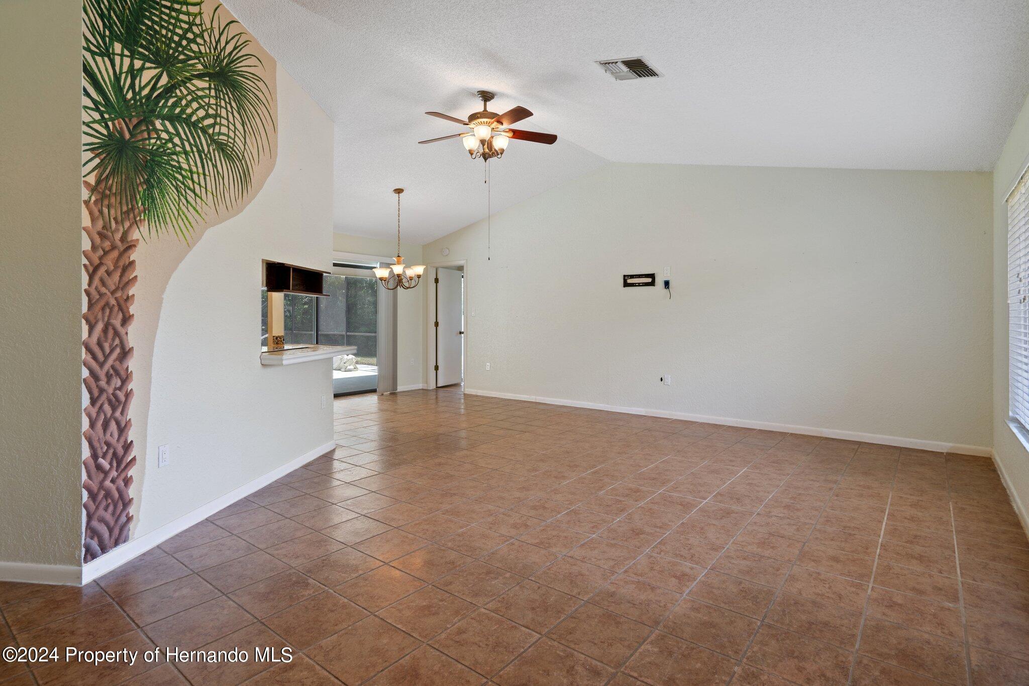 9290 Eldridge Road Spring Hill, FL 34608 - Photo 8 of 55 a view of a livingroom with a chandelier fan and wooden floor