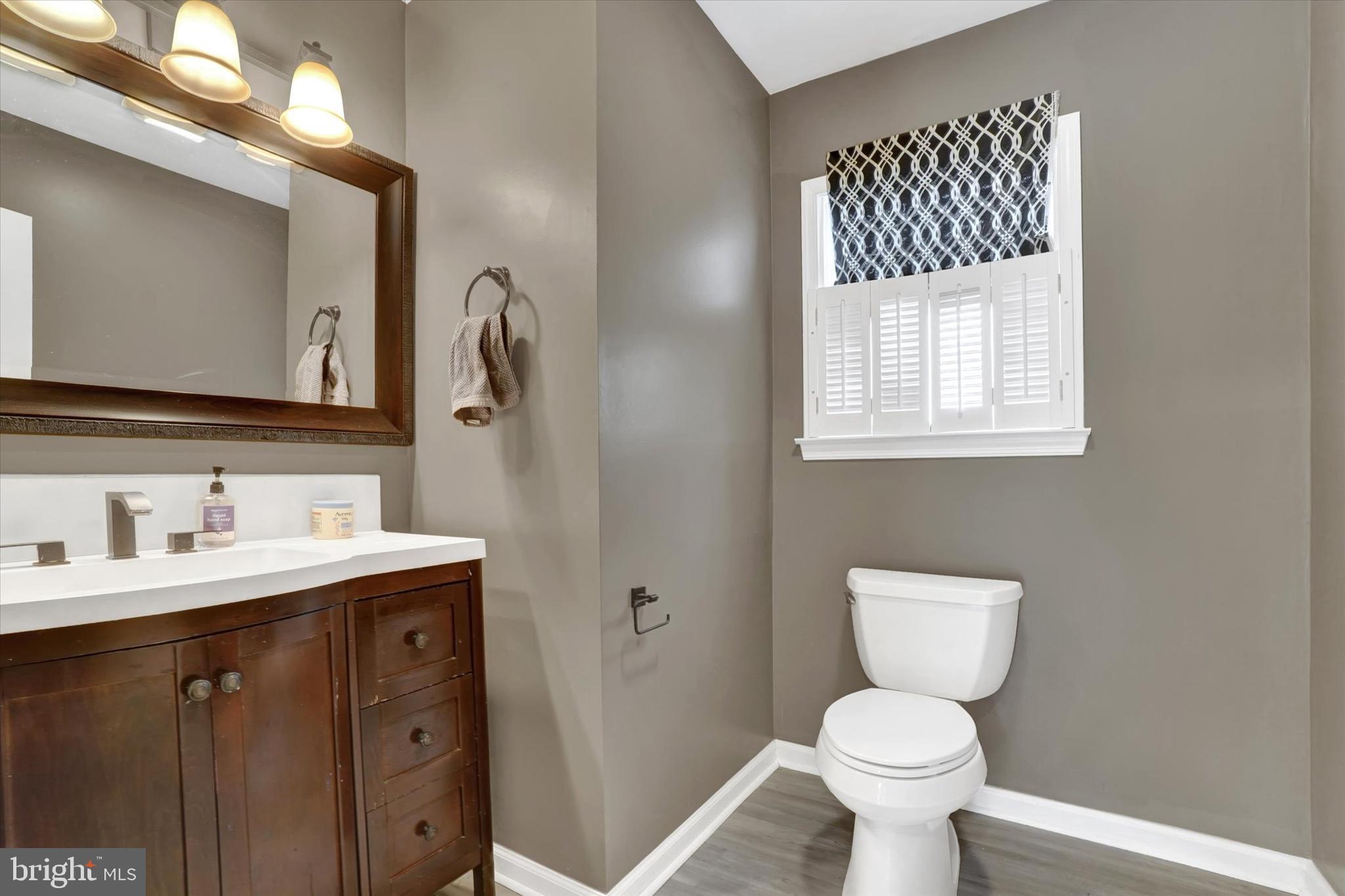 3 Harrison Road New Freedom, PA 17349 - Photo 12 of 28 a bathroom with a toilet sink a mirror and window