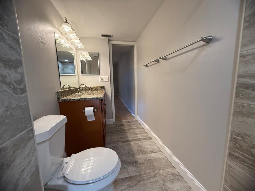 208 Palmetto Court, Unit 208 Oldsmar, FL 34677 - Photo 16 of 48 a bathroom with a granite countertop toilet and a mirror