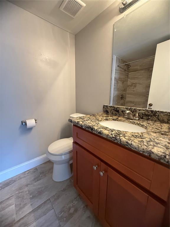 208 Palmetto Court, Unit 208 Oldsmar, FL 34677 - Photo 22 of 48 a bathroom with a granite countertop sink a toilet and a mirror