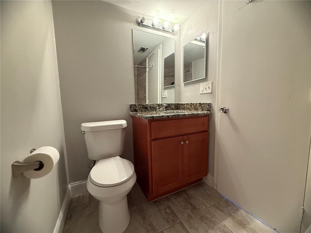 208 Palmetto Court, Unit 208 Oldsmar, FL 34677 - Photo 23 of 48 a bathroom with a granite countertop toilet sink and mirror