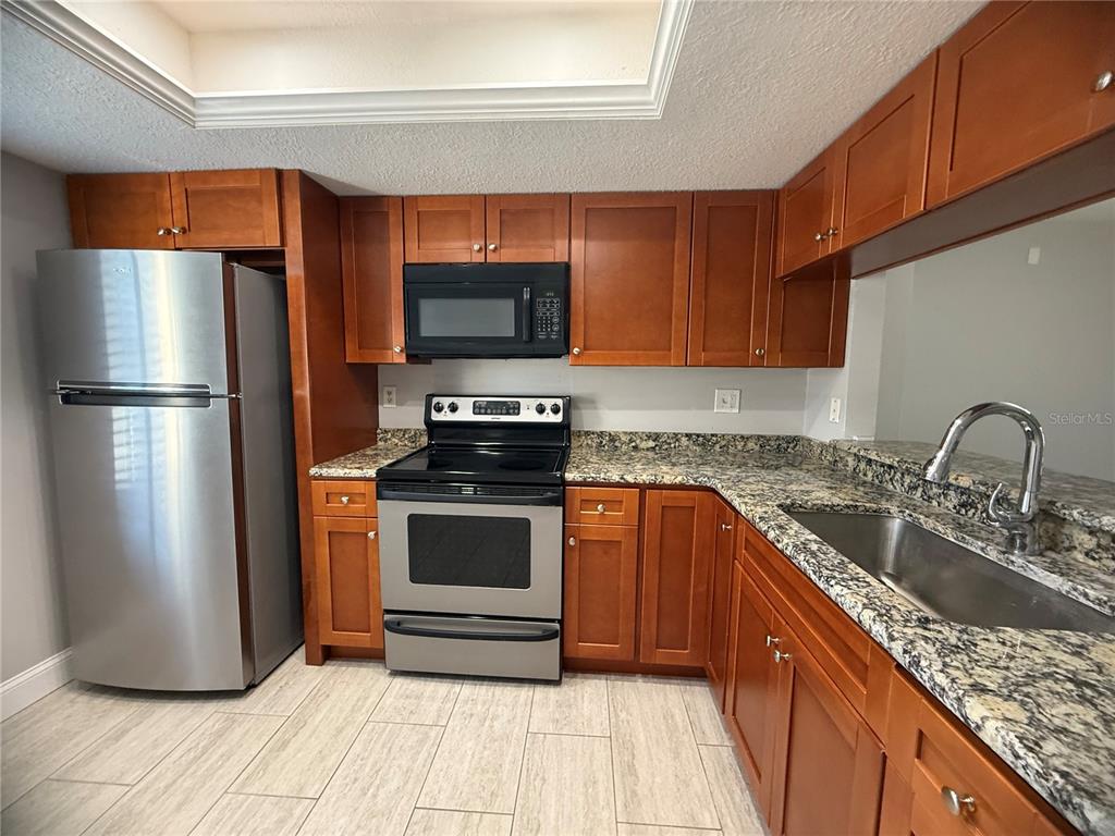 208 Palmetto Court, Unit 208 Oldsmar, FL 34677 - Photo 6 of 48 a kitchen with a refrigerator sink and microwave